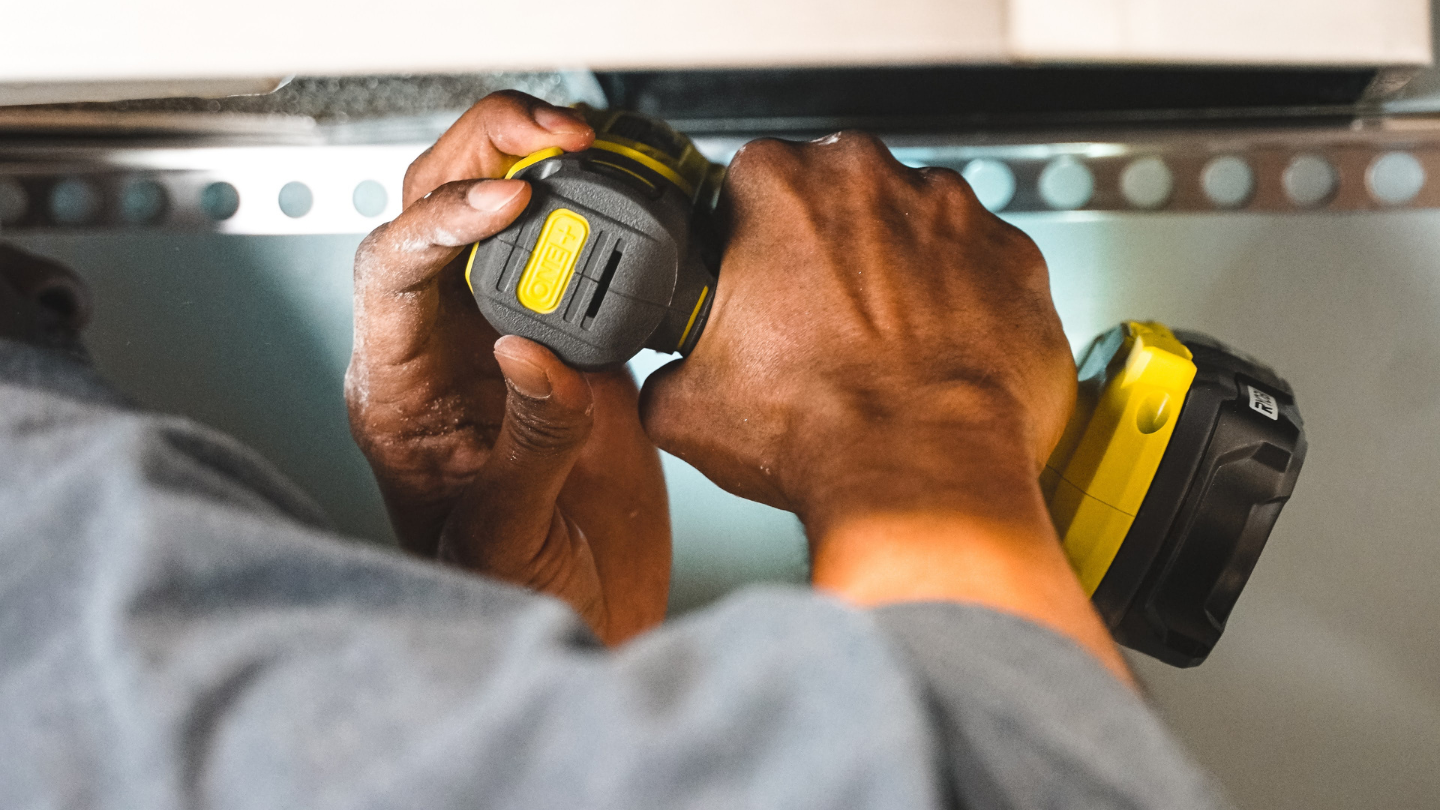 Close-up of hands operating a drill during building maintenance