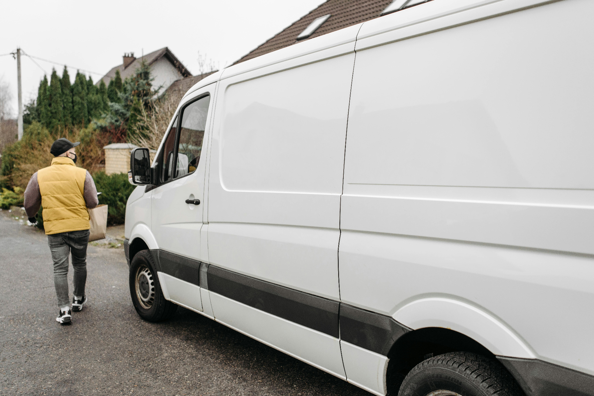 Trade service van parked at a multi-family residential building entrance
